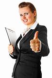 Smiling modern business woman with clipboard  showing thumbs up gesture
