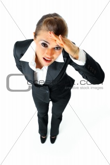 Attentive modern business woman holding hand at  forehead and looking away 
