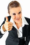 Smiling modern business female showing thumbs up gesture
