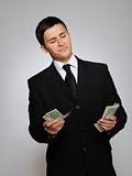 Young handsome business man in black suit and tie counting money