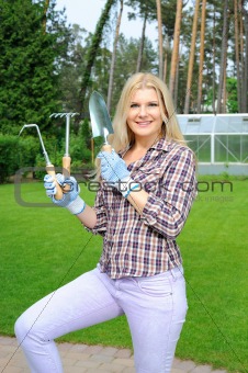 Pretty gardener woman with gardening tools outdoors. greenhouse 