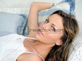 portrait of Young pretty woman relaxing on a sofa in her home