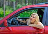 beautiful woman driver in red shiny car outdoors smiling