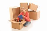 Young woman unpacking cardboard boxes