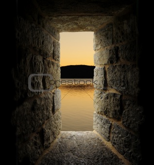 Viewing a lake or moat through a stone castle-like window