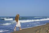 Little girl running beach in blue sea