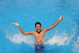boy teenager splashing water open arms pool