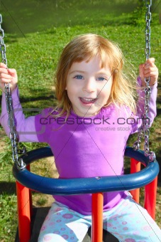 girl swinging on swing happy in meadow grass park