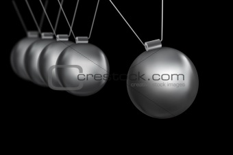 newtons cradle silver balls on black background