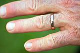 Hand of a man with a golden wedding ring on his ring finger