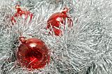 Red glass baubles on silver tinsel.