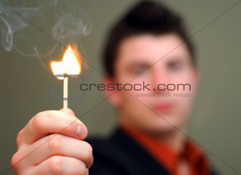 Young Man Holding Flaring Match