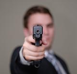Businessman Points Gun with Shallow Depth of Field