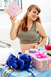 Smiling  beautiful pregnant woman sitting on couch with gifts for her unborn baby
