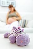 Toy lying on table and pregnant woman sitting on sofa  in background
