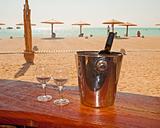Wine bottle and glasses on a beach bar