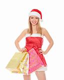 Pretty girl in a red Christmas hat with colorful bags isolated