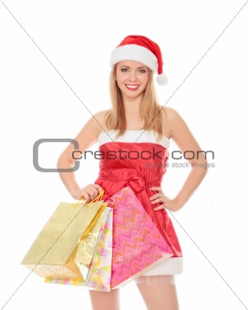 Pretty girl in a red Christmas hat with colorful bags isolated