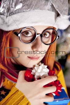 Funny girl in christmas cap with gift boxes 