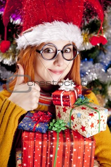 Funny girl in christmas cap with gift boxes 