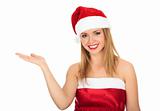 Pretty girl wearing red Christmas hat, holding a hand palm up.