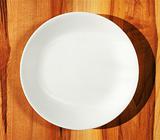 White dinner plate on wood table