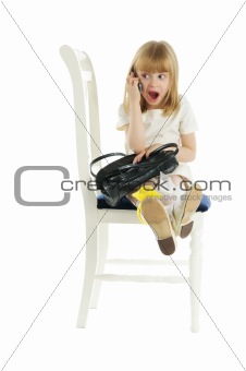 Surprised girl with phone on chair