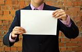 Business man holding a blank white sheet of paper