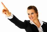 Smiling modern business woman pointing  finger in  corner
