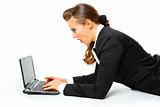 Modern business woman laying on floor and amazedly looks in laptops screen
