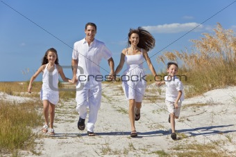 Mother, Father and Children Family Running Having Fun At Beach