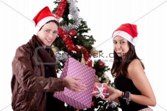 happy young couple, opening gifts beside Christmas tree, isolated on white