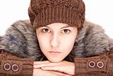 Beautiful young woman with pullover and cap looks serious.