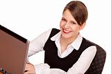 Young happy business woman sits on desk and works on laptop