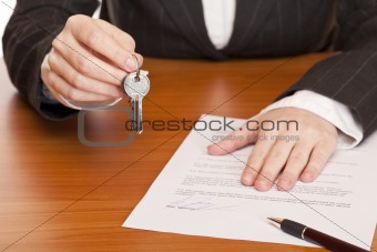 Business woman holds key and contract in hands
