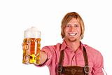 Happy smiling man with leather trousers (lederhose) holds oktoberfest beer stein