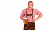 Bavarian man with leather trousers (lederhose) holds oktoberfest beer stein in hand