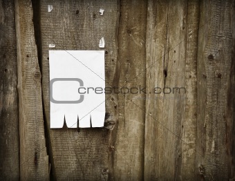 Paper advertisement on wooden fence