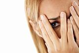 shy woman looking through fingers