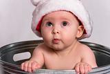 Baby with Santa Hat sitting in Wash Basin