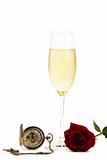 cold glass with champagne with a red rose and a old pocket watch