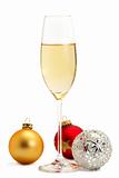 glass of champagne with golden, red and metal christmas balls