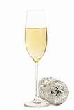 glass of champagne with two metal christmas balls