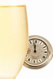 old pocket watch behind a cold glass with champagne