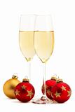 two glasses with champagne with one golden and three red christmas balls