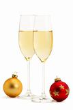 two glasses with champagne and one red and golden christmas balls