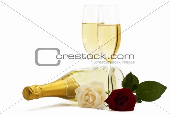 red and cream-colored roses with two champagne glasses and a champagne bottle
