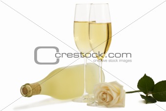 creamy rose in front of two champagne glasses and a prosecco bottle