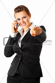  Smiling modern business woman talking on mobile phone and  pointing finger at you
