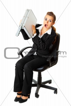 Shocked modern business woman searching  something in briefcase 

